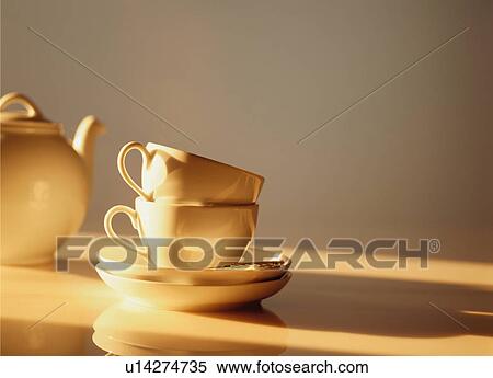 Stock Photography - Two white coffee cups and teapot on table. Fotosearch