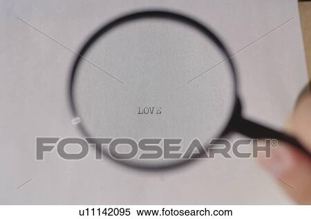 Stock Photography - Typed word love magnified in magnifying glass. Fotosearch