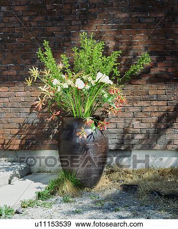 Vase of flowers outside a brick building View Large Photo Image Stock Photo - Vase of flowers outside a brick building. Fotosearch