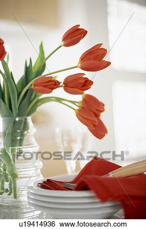 Stock Photograph - Vase of red tulips and tableware on a kitchen counter. Fotosearch