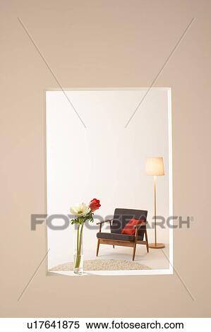 Stock Photography - Vase with flowers on window looking into lounge. Fotosearch