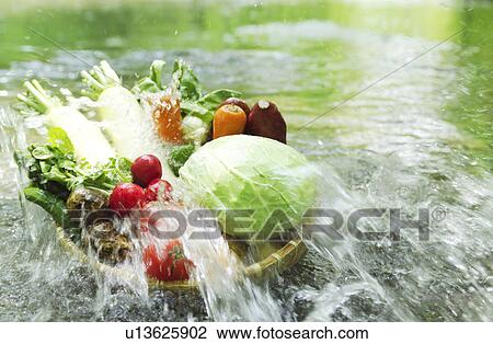 Stock Image - Vegetables washed in river. Fotosearch