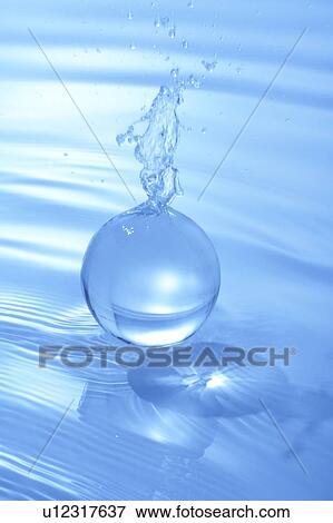 Stock Photo - Water running out of ball, blue background. Fotosearch