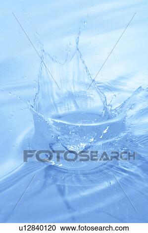 Stock Image - Water splashing, close up, blue background. Fotosearch