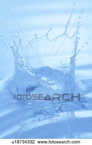 Stock Image - Water splashing, close up, blue background. Fotosearch