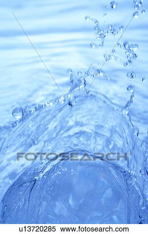 Stock Photography - Water splashing, close up, blue background. Fotosearch