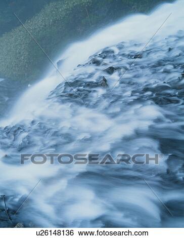Waterfall flowing over rocks View Large Photo Image Stock Photograph - Waterfall flowing over rocks. Fotosearch