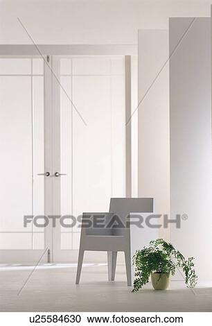 Stock Image - White chair and potted plant. Fotosearch