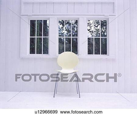 Stock Photo - White chair below window in white room. Fotosearch
