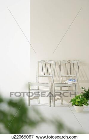 Stock Photo - White chairs in house with potted plants. Fotosearch
