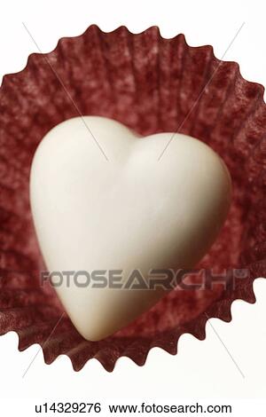 Stock Photograph - White chocolate heart in a cupcake wrapper. Fotosearch