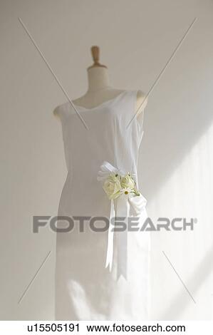 Stock Image - White dress with corsage, white background. Fotosearch