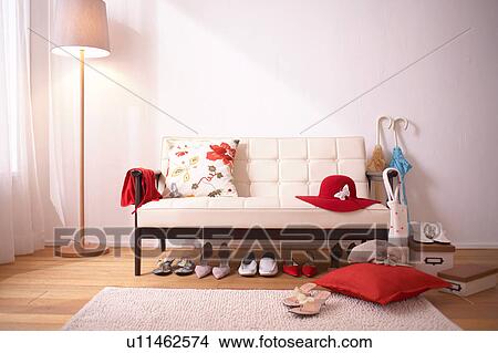 Picture - White sofa in living room with shoes. Fotosearch