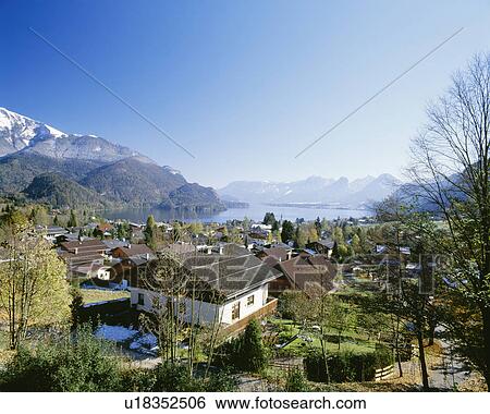 Stock Photograph - Wolfgangsee with surrounding mountains and village, St. Gilgen, Salzkammergut, Austria. Fotosearch