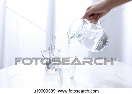 Woman pouring water View Large Photo Image Stock Photo - Woman pouring water. Fotosearch