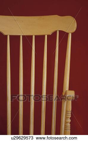 Stock Image - Wooden chair against red wall. Fotosearch