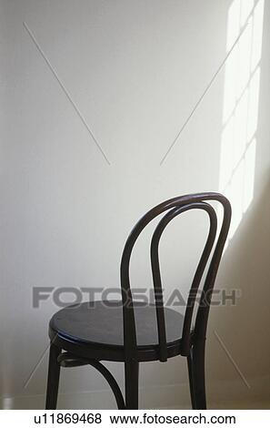 Stock Photo - Wooden chair facing white wall. Fotosearch