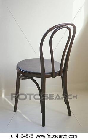 Stock Photograph - Wooden chair facing white wall. Fotosearch