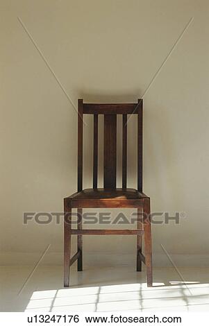 Wooden chair next to shadow cast by window View Large Photo Image Stock Photograph - Wooden chair next to shadow cast by window. Fotosearch