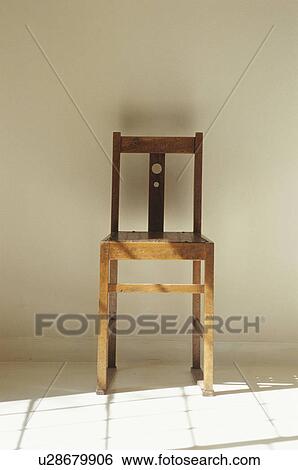 Stock Photograph - Wooden chair next to shadow cast by window. Fotosearch