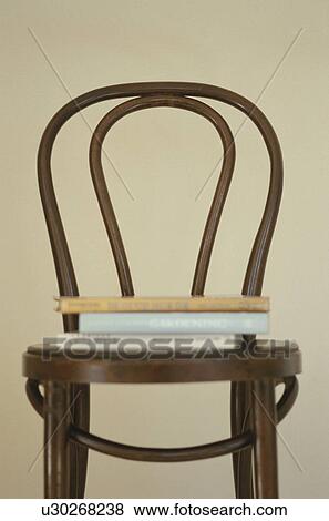 Wooden chair with books stacked on it View Large Photo Image Stock Photo - Wooden chair with books stacked on it. Fotosearch