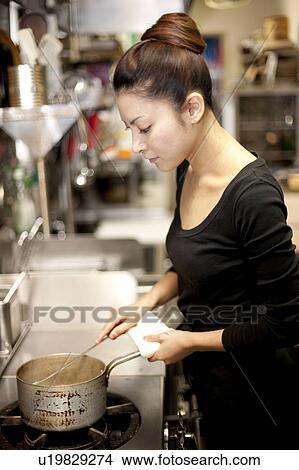 Picture - Young Woman Cooking at Kitchen in Restaurant. Fotosearch
