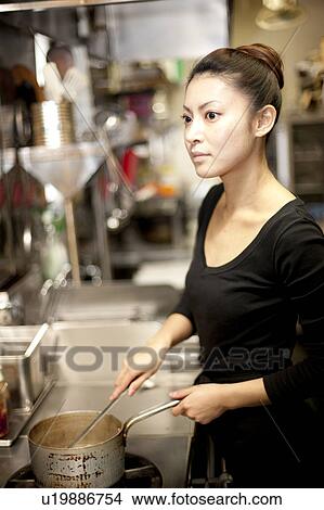 Picture - Young Woman Cooking at Kitchen in Restaurant. Fotosearch