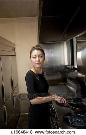 Stock Photo - Young Woman Cooking at Kitchen in Restaurant. Fotosearch