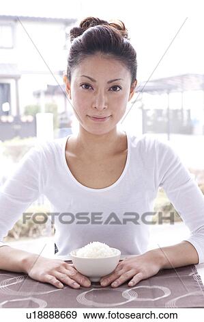 Young Woman Holding Bowl of Rice at Table View Large Photo Image Stock Photo - Young Woman Holding Bowl of Rice at Table. Fotosearch