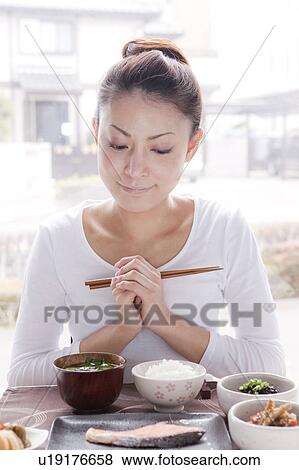 Stock Photo - Young Woman Holding Chopsticks. Fotosearch