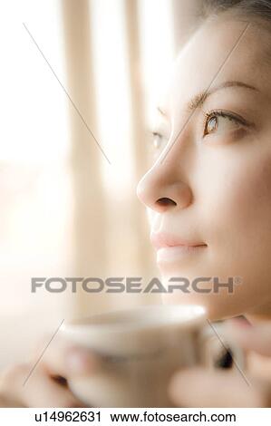 Stock Image - Young Woman Holding Coffee Cup. Fotosearch