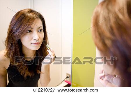 Young Woman Making Up, Looking at Mirror View Large Photo Image Stock Photo - Young Woman Making Up, Looking at Mirror. Fotosearch