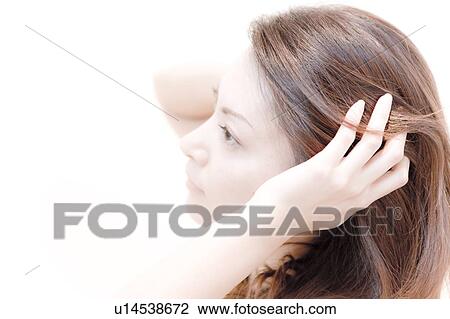 Stock Image - Young Woman Running Her Hands Through Her Hair. Fotosearch