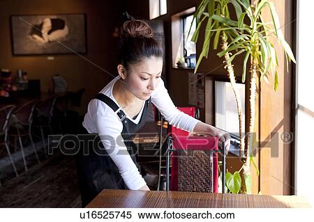 Stock Photography - Young Woman Setting Chair. Fotosearch