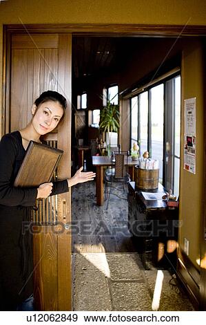 Stock Photo - Young Woman Standing at Entrance of Café. Fotosearch