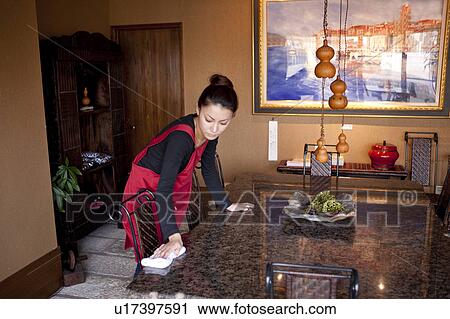 Stock Image - Young Woman Wiping Table. Fotosearch