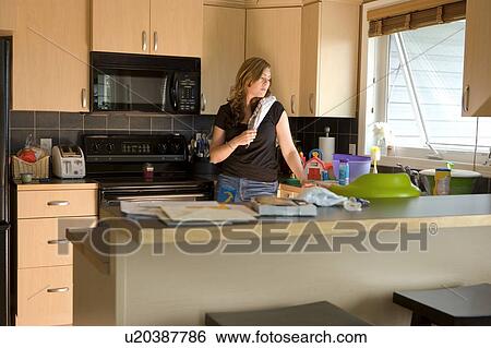 Stock Photograph - A woman in the kitchen. Fotosearch