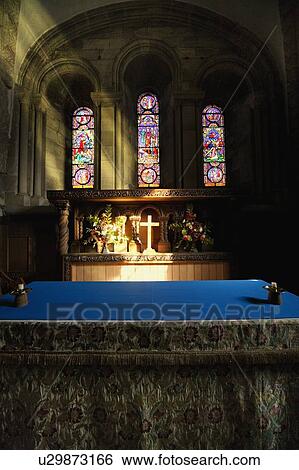 Stock Photograph - Cross illuminated at the altar of a church. Fotosearch