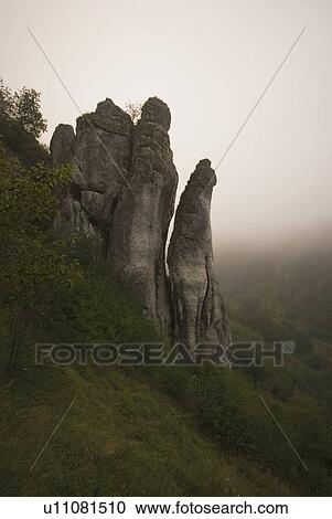 Stock Image - Rocky cliff in the fog. Fotosearch