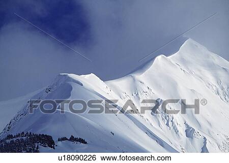 Stock Photograph - Snow cornice leading up to mountain peak. Fotosearch