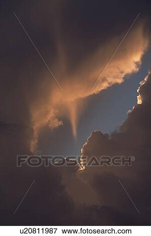 Stock Photo - Sun beam passes through clouds. Fotosearch