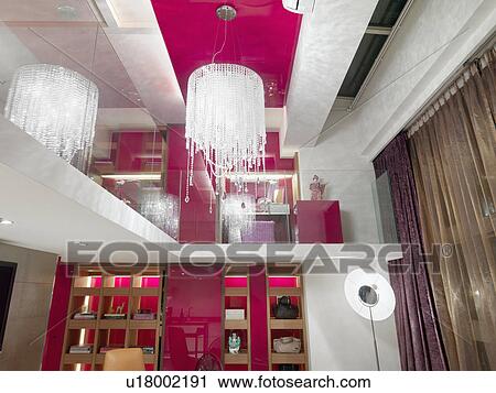 Stock Image - Beaded chandelier and pink walls in apartment home. Fotosearch