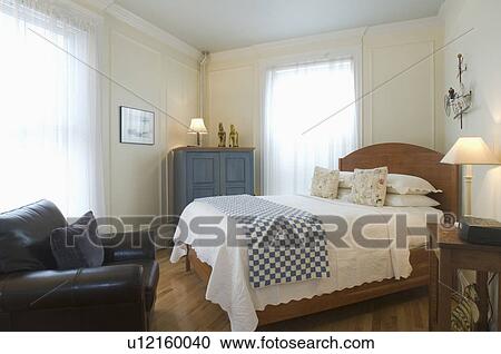 Stock Image - Bed and armchair in small studio apartment. Fotosearch