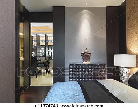 Stock Image - Bed and doorway in modern bedroom. Fotosearch