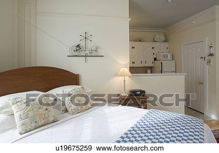 Stock Photo - Bed in small studio apartment. Fotosearch