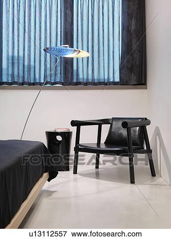 Stock Photo - Black chair and modern bed. Fotosearch