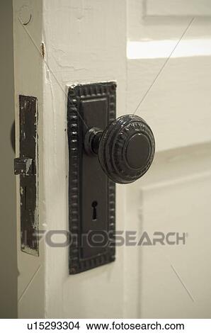 Picture - Black doorknob and skeleton keyhole on wooden door. Fotosearch