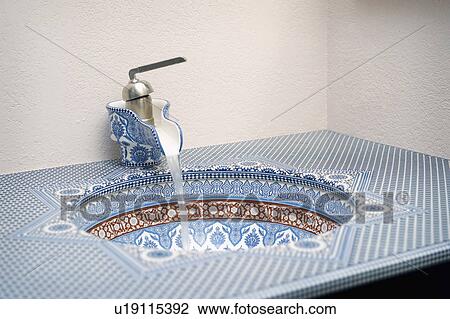Stock Image - Blue and red geometric patterned bathroom sink. Fotosearch