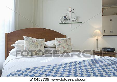 Stock Photo - Blue and white checked blanket on bed. Fotosearch