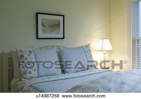 Stock Photo - Blue and yellow bedspread on bed. Fotosearch